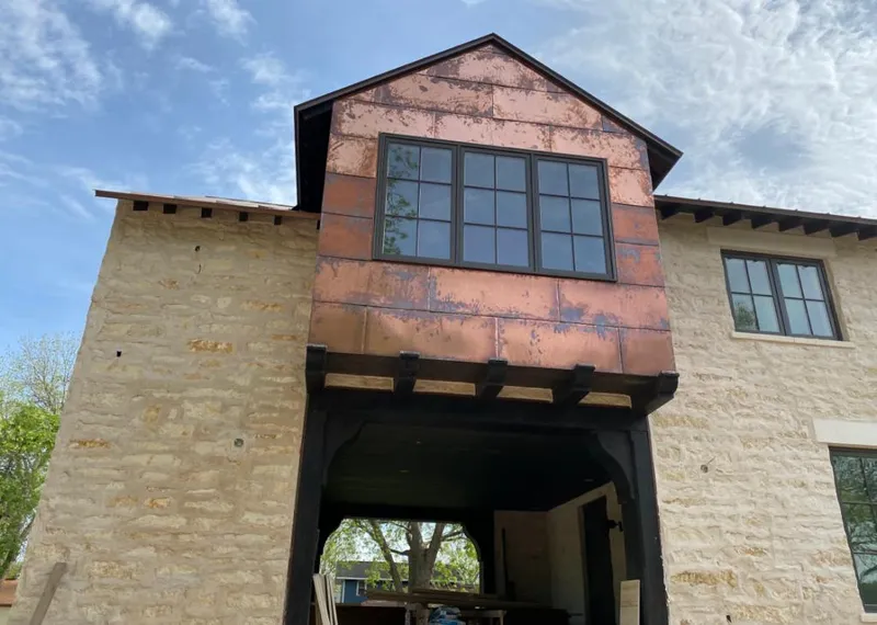 Copper metal panel facade on a stone building for Roof Repair in Shorewood